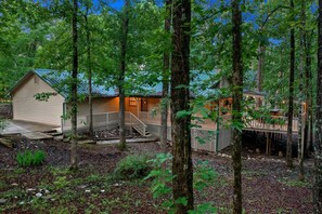 Eine Holzhütte mit einer Holzterrasse, umgeben von Bäumen.