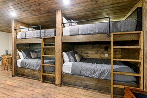 A bunk bed room with wooden beams, a ladder, and a small table with a plant. - Wonderful Cabin Perfect for Family Getaways in Broken Bow, Oklahoma (Broken Bow)