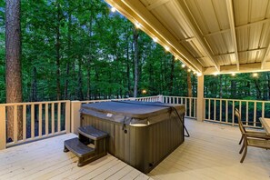 A hot tub on a wooden deck with railings, surrounded by trees. - Wonderful Cabin Perfect for Family Getaways in Broken Bow, Oklahoma (Broken Bow)