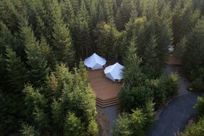 A forested area with two white tents on a wooden deck. - Large and Spacious Double Bell Tents Great for Families in Carson, Washington (Carson)