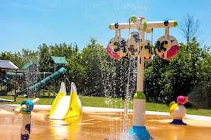 Un área de juegos acuáticos con múltiples chorros de agua y toboganes.