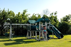 A playground with a slide and swings.