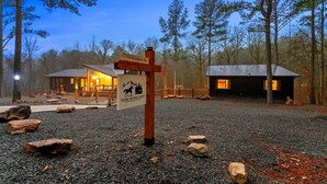 A rustic lodge with a sign indicating '75 Sturgeon Rd' and 'Dark Horse Loft.' - Garage Loft • King + Bunks • Budget Friendly near Beavers Bend National Park (Broken Bow)