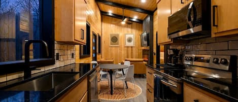 A modern kitchen with wooden cabinetry, a central island, and built-in appliances.