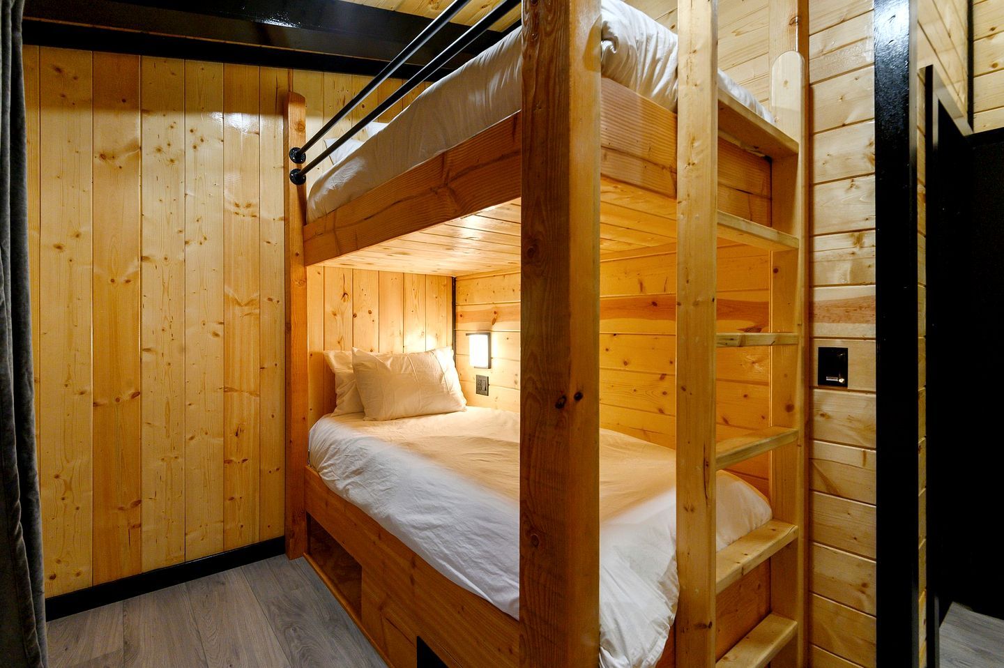 A bunk bed room with wooden walls and a ladder.