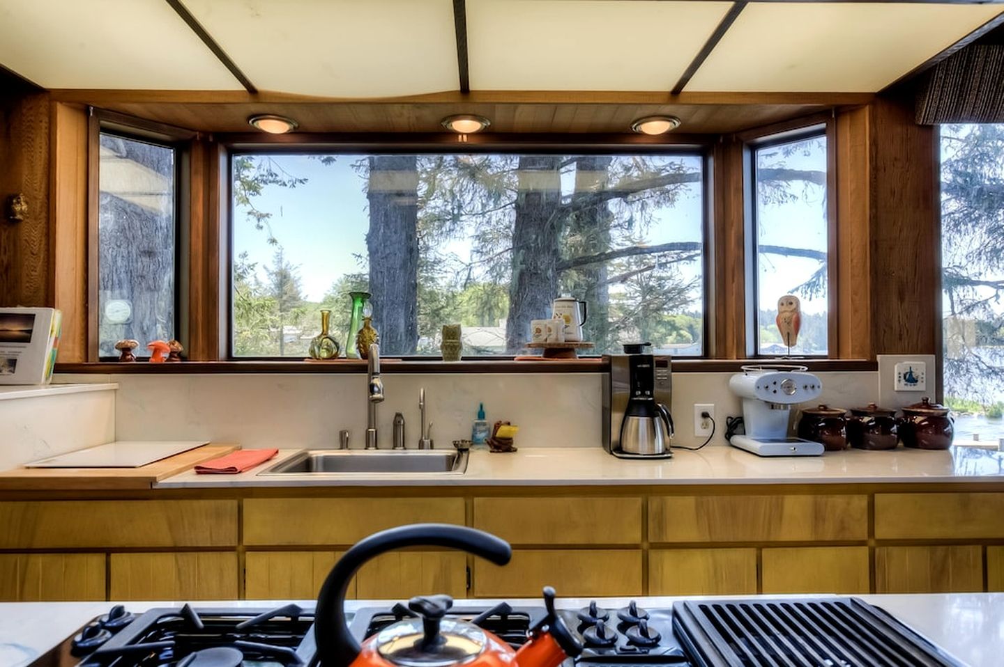 Una cocina moderna con un amplio ventanal, estufa y diversos electrodomésticos.