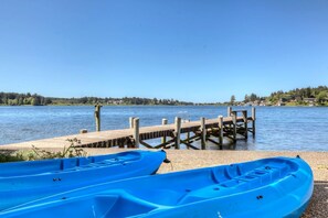 A wooden dock extending into calm water, with a clear sky above.