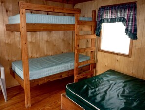 A bunk bed room with a window and a curtain.