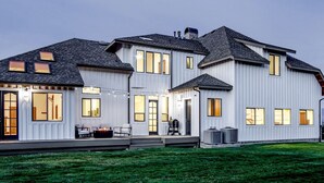 A large, modern two-story house with a covered porch and multiple windows. - Breathtaking Cottage with Hot-tub in Eagle Mountain, Utah (Eagle Mountain)