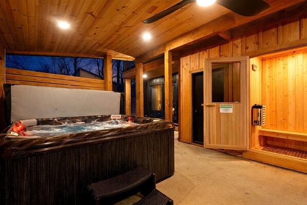 A wooden spa area with a hot tub, benches, and a sauna.