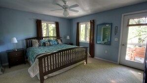 A bedroom with a bed, two nightstands, a ceiling fan, and a door leading to an outdoor area. - Beautiful Cabin with Hot Tub Surrounded by Trees in Confluence, Pennsylvania (Confluence)