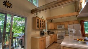 A kitchen with wooden cabinets, a microwave, an oven, and a sink. - Beautiful Cabin with Hot Tub Surrounded by Trees in Confluence, Pennsylvania (Confluence)