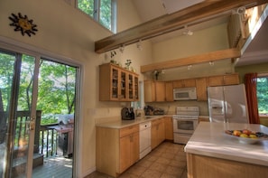 A kitchen with wooden cabinets, a microwave, an oven, and a sink. - Beautiful Cabin with Hot Tub Surrounded by Trees in Confluence, Pennsylvania (Confluence)