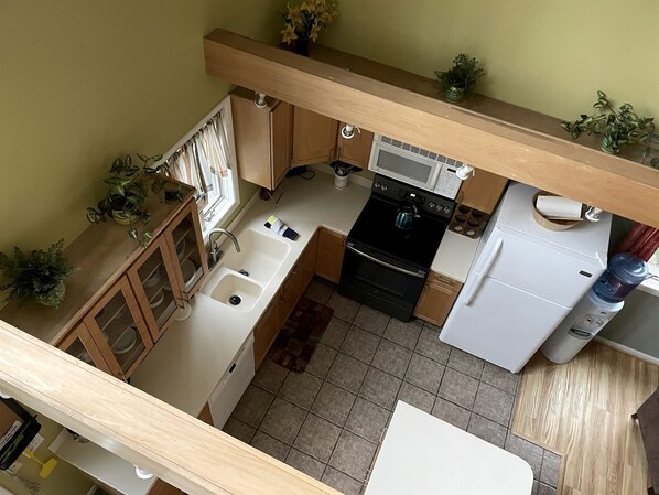 A kitchen with a microwave, stove, sink, and cabinets.