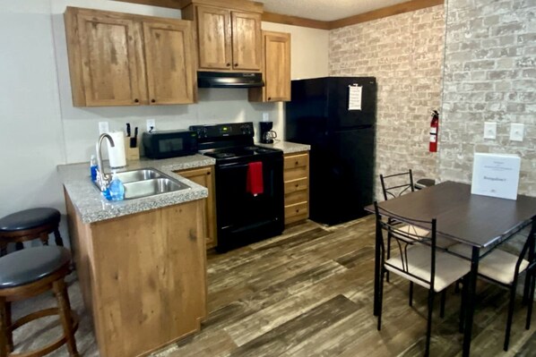 Fridge, coffee/tea maker, cookware/dishes/utensils, dining tables