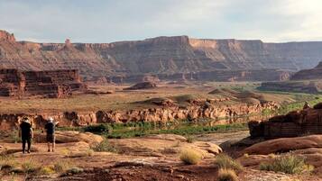 Een uitgestrekt canyonlandschap met gelaagde rotsformaties.