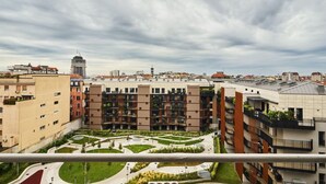 A modern apartment complex with multiple buildings, a central courtyard, and a view of the surrounding cityscape.