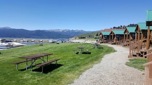 A lakeside lodge with wooden cabins, picnic tables, and boats docked by the water. - Fantastic Cabin with Fire Pit Close to West Yellowstone, Montana (West Yellowstone)