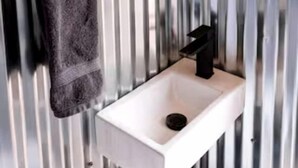 Ein Badezimmer mit Waschbecken, Handtuchhalter und Spiegel.
