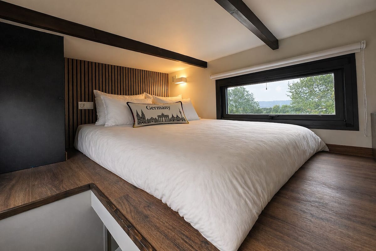 Una camera da letto con un letto, una finestra e vista su del verde.