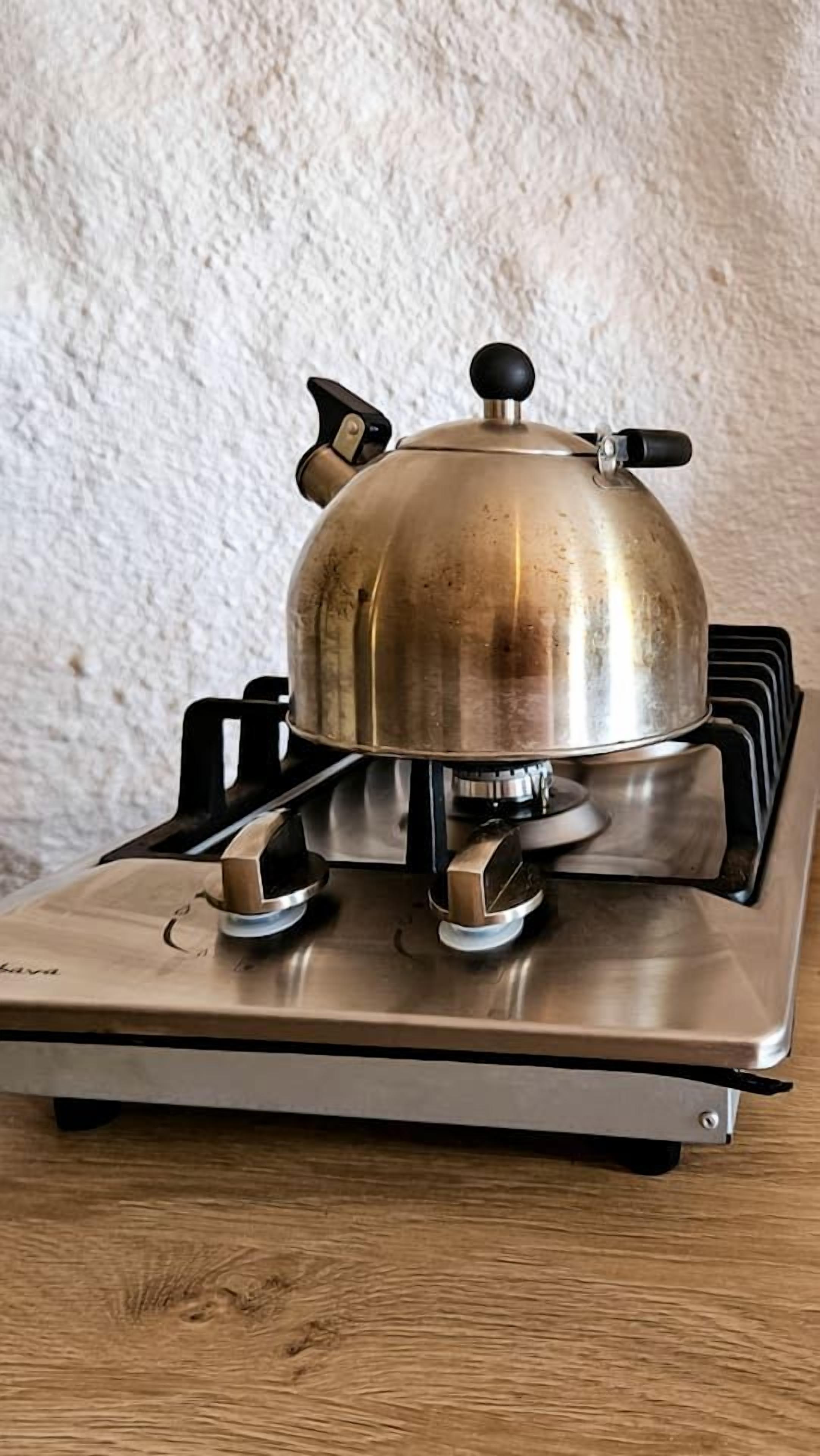 A gas stove with a pot on top, a control knob, and a burner.
