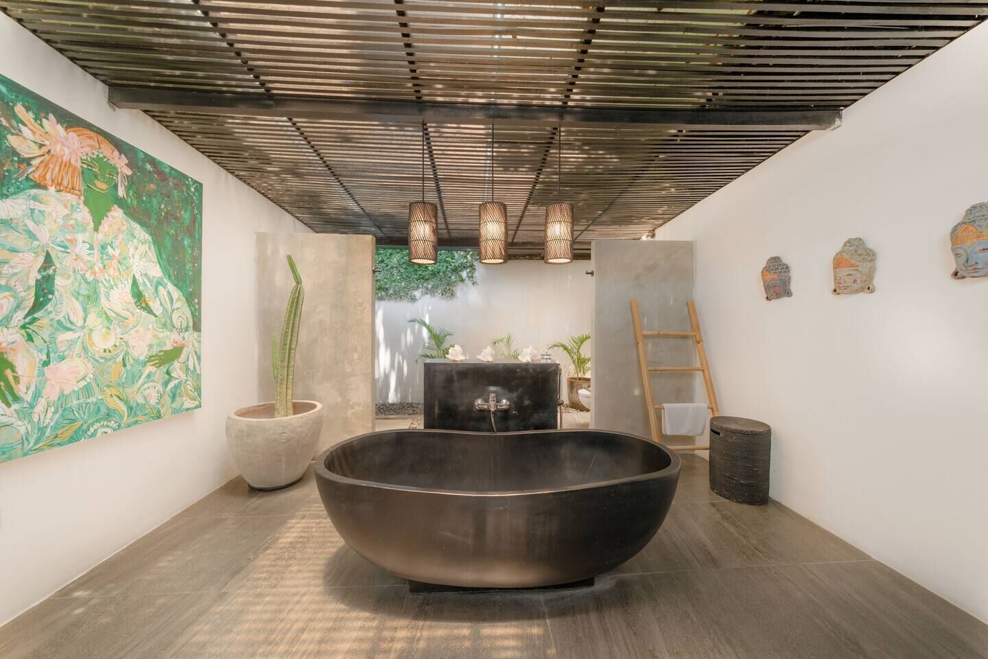 A modern bathroom with a large freestanding bathtub, a concrete sink, and a wooden ladder.