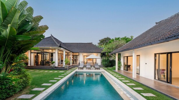 Une maison moderne avec une piscine, deux bâtiments distincts et un jardin bien entretenu.