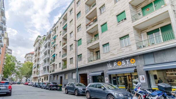 A multi-story building with a cafe named 'IL POSTO' on the ground floor.