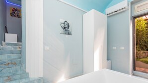 A bathroom with a bathtub, a shower, and a window with a view of greenery. - Sp Luxury - Catania – Room 2 (Catania)