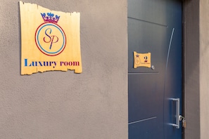 Una puerta con un cartel que indica 'Habitación de lujo' y el número '2'.