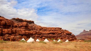 A desert landscape with red rock formations and white tents. - Beautiful Glamping Tent for an Unforgettable Family Escape near Canyonlands National Park in Moab, Utah (Moab)