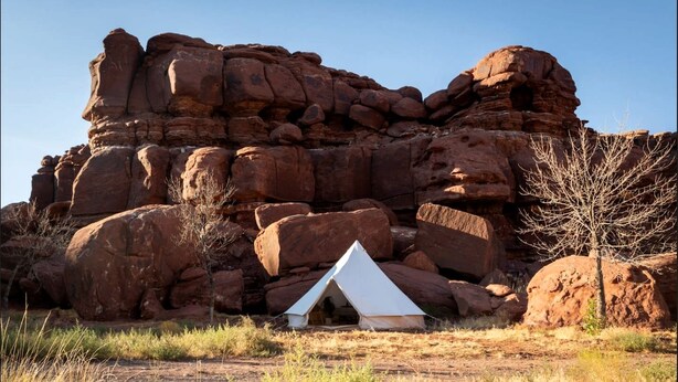 A tent in a rocky outdoor setting.