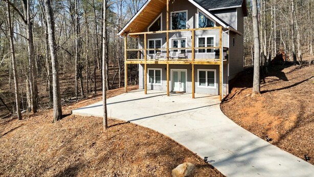 A two-story house with a balcony, surrounded by a wooded area. - Spacious Family Cabin with Lake Hartwell Access in Westminster, South Carolina (Westminster)
