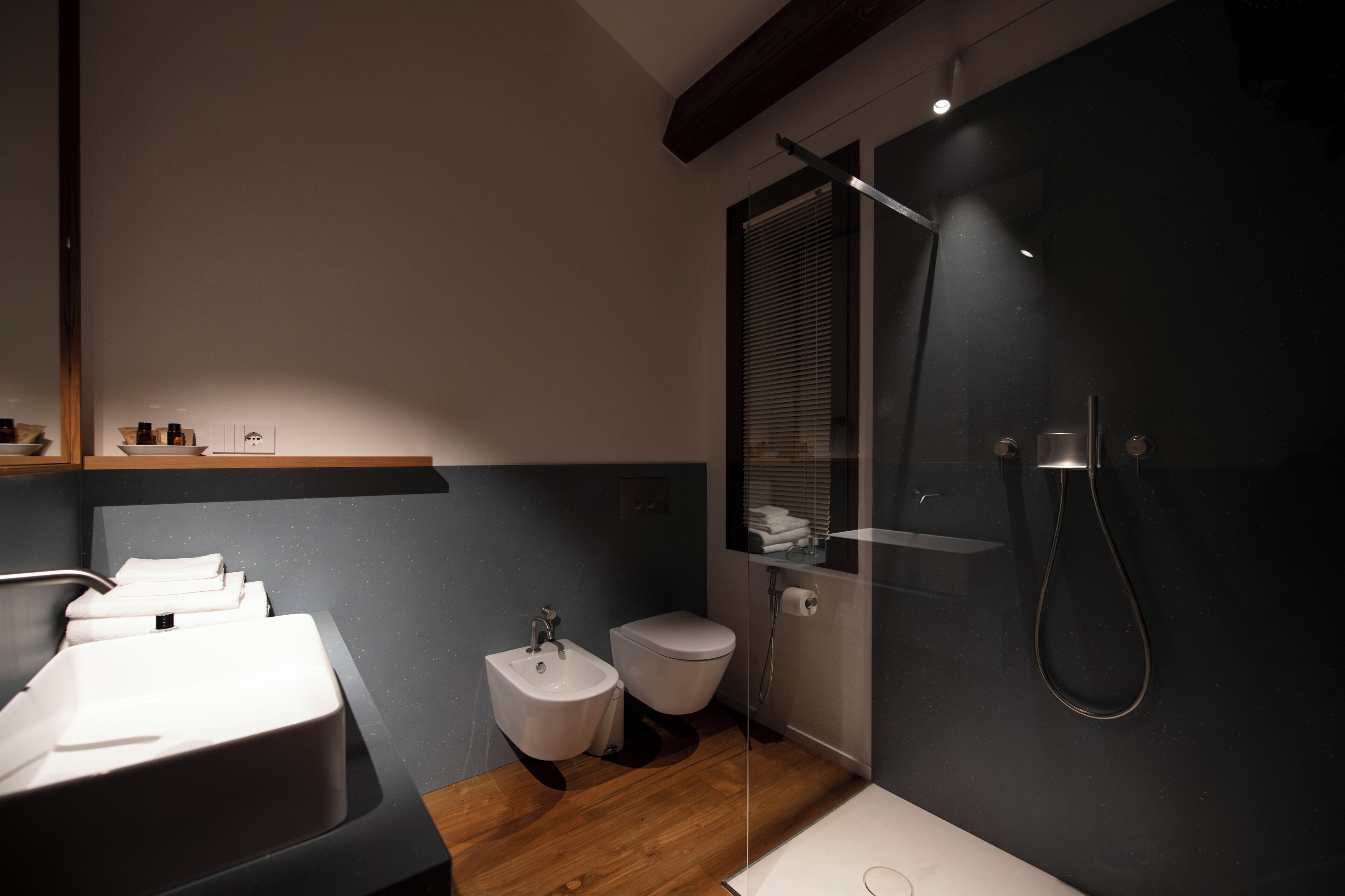 Une salle de bain moderne équipée d’un lavabo, d’un bidet, de toilettes et d’une douche.