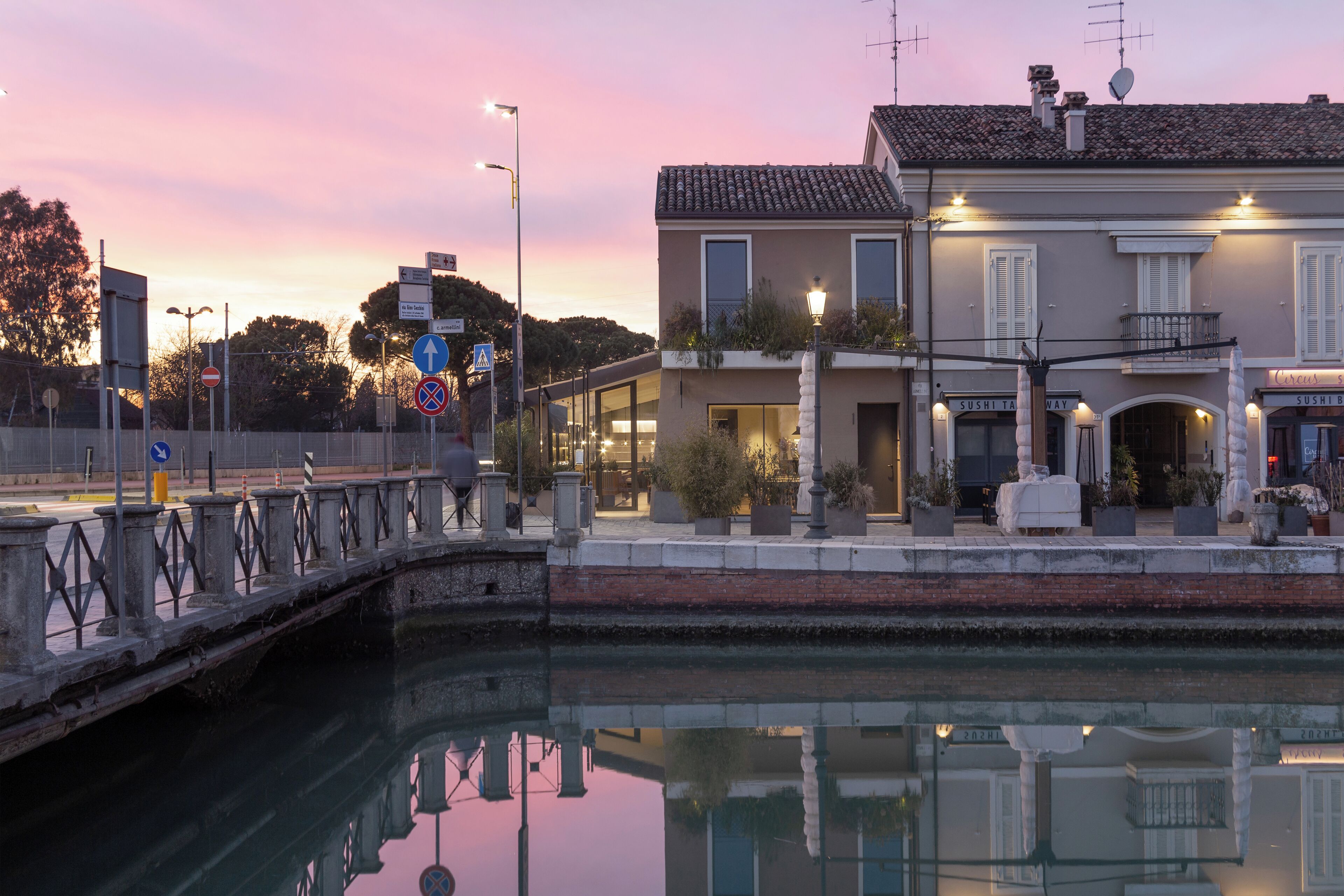 Un edificio sul lungomare con un ristorante chiamato "Sushi Ta" e un segnale che indica divieto di sosta.