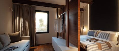 Une chambre moderne avec un canapé, un lit avec une literie à rayures, des poutres en bois et une fenêtre avec des rideaux.