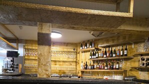 A bar area with shelves of bottles, glasses, and a counter. - Old Ridgeway Hotel (London)