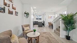 Un salon moderne avec un canapé, une table basse et un escalier menant à un espace repas.