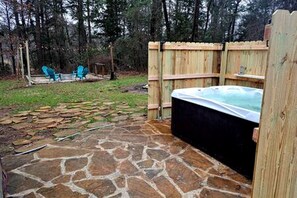 A hot tub in a wooden enclosure with a stone patio. - Fantastic Dome with Private Yard, Hot-Tub and Fire Pit in Texas (Bullard)