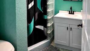 Un baño con cortina de ducha, lavamanos, espejo y armario.