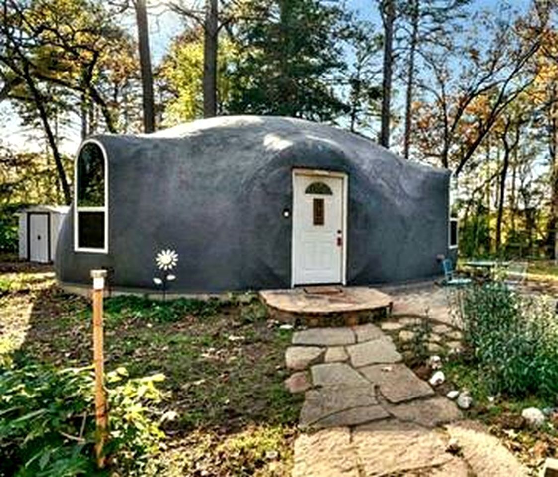 A geodesic dome structure with a door and a small porch.