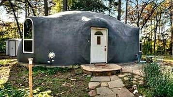 A geodesic dome structure with a door and a small porch.