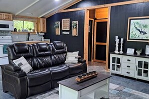 A living room with a leather sofa, a coffee table, and a cabinet with glass doors.