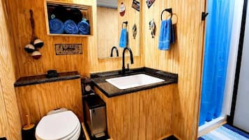 A wooden-themed bathroom with a sink, toilet, and a mirror.