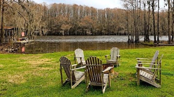 Nurmikkoalue, jolla on useita puisia Adirondack-tyylisiä tuoleja, jotka on aseteltu puolipiiriin. Alueelta avautuu näkymä tyyneen järveen, jonka taustalla kohoaa puita.