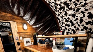 Une cuisine de taille réduite, dotée d’un plan de travail en bois, d’un évier et d’une machine à café.