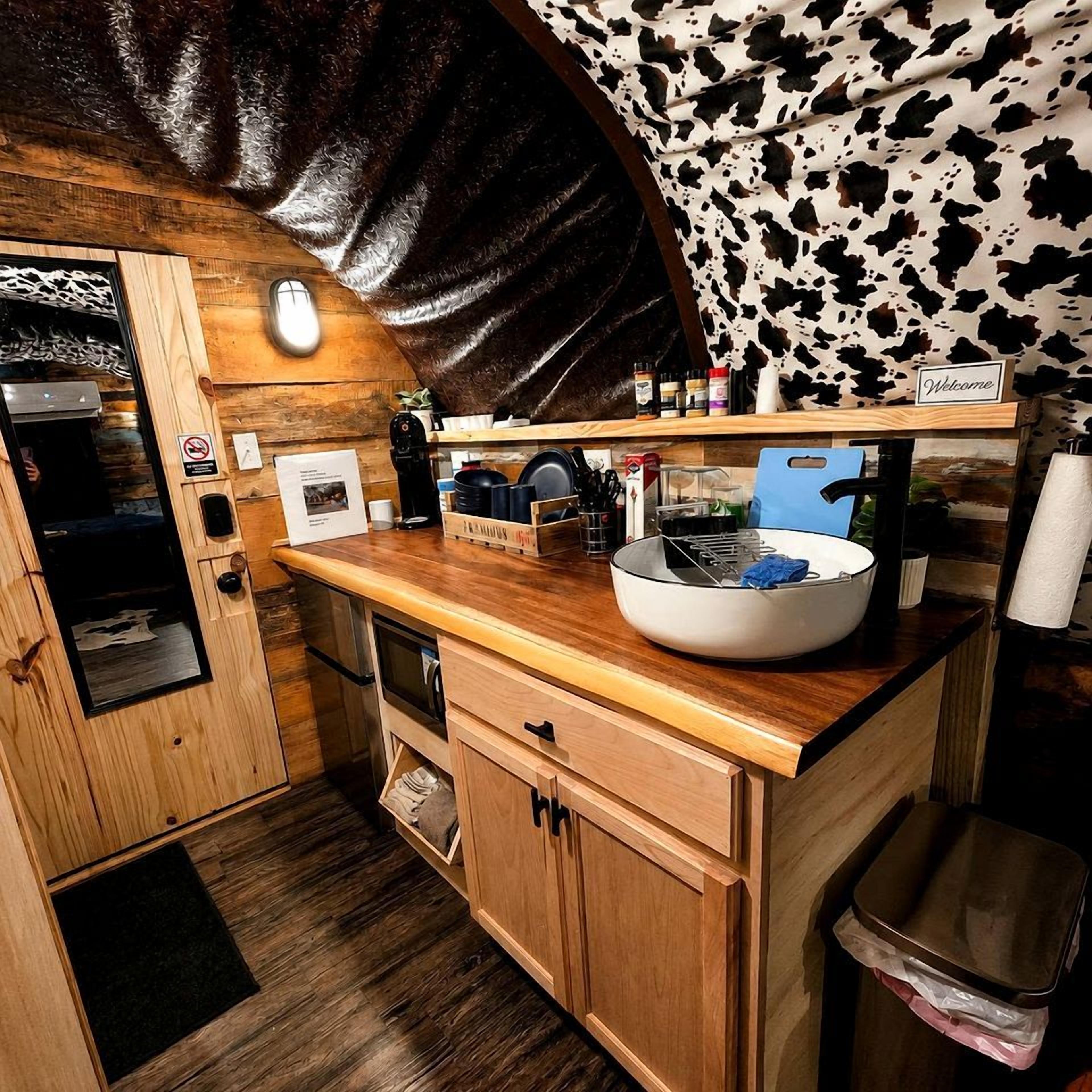 Una cocina compacta con encimera de madera, un fregadero y una cafetera.