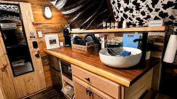 Una cocina compacta con encimera de madera, un fregadero y una cafetera.