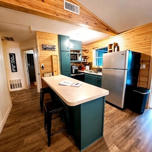 A kitchen with wooden walls, a central island, and modern appliances.