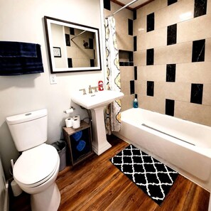 A bathroom with a toilet, sink, and bathtub.